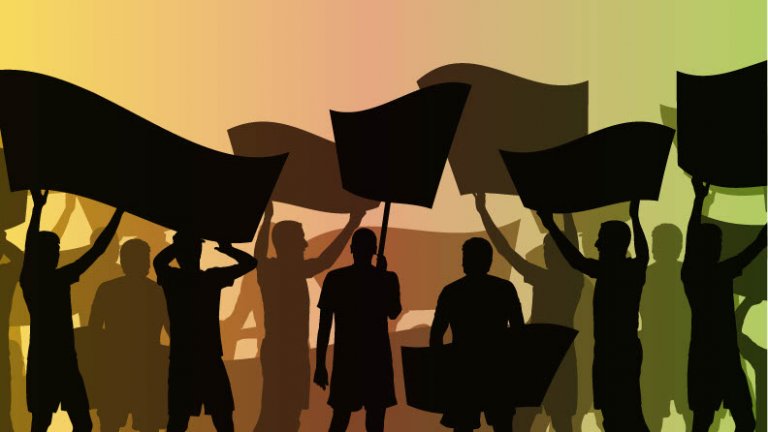 Shadow images of people holding banners at a rally.