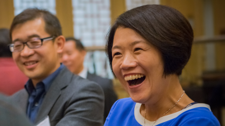 Global Affiliate alumni smiling, in conversation during an alumni reception.