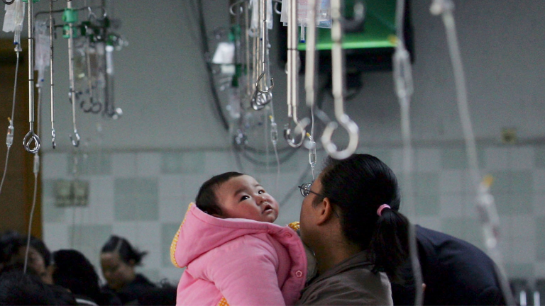A parent holds a child waiting to be given an infusion at an area hospital in China.