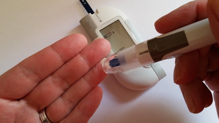 Closeup on hands holding a glucometer