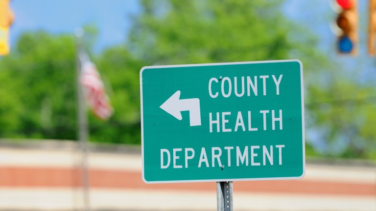 A traffic sign pointing to the county health department.