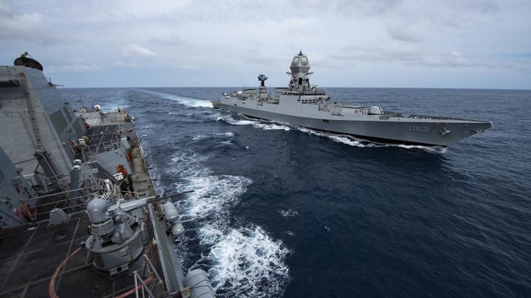 Two destroyer navy ships sail alongside each other