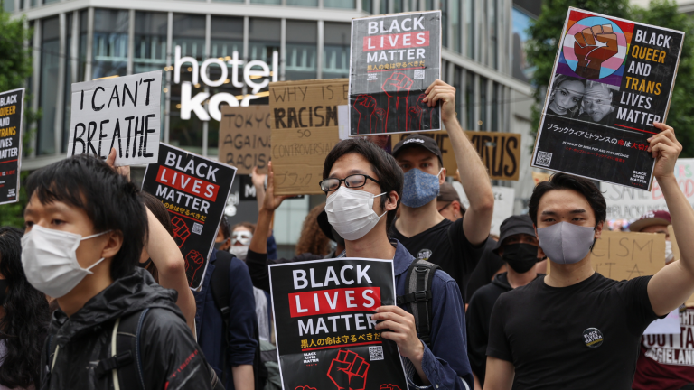 Protesters hold signs and chant slogans during a Black Lives Matters Peaceful March on June 14, 2020 in Tokyo, Japan.
