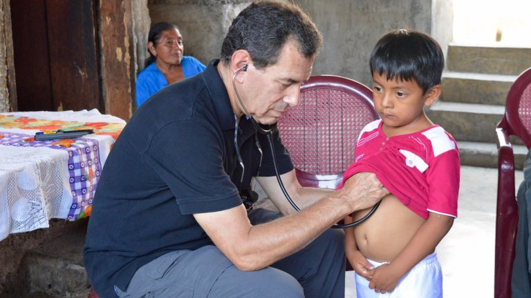 Stanford Health Policy's Paul Wise treats a boy in Guatemala.