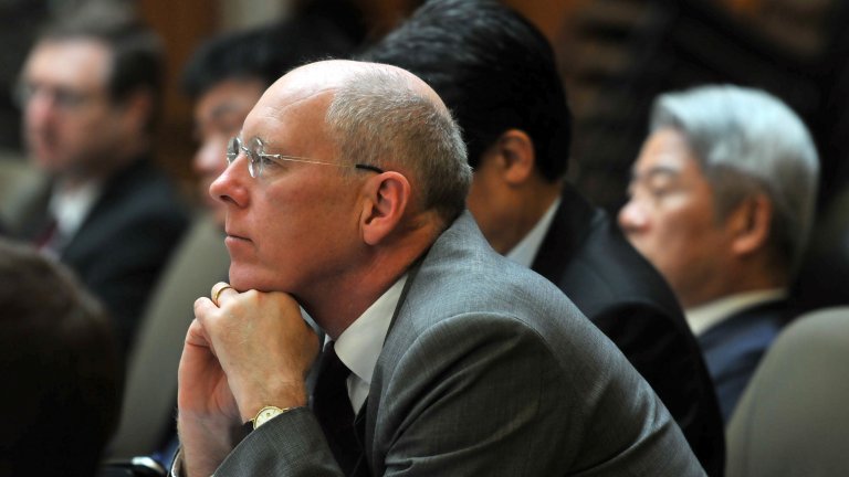 British diplomat John Everard seated at a Korea Program roundtable, listening to a discussion.