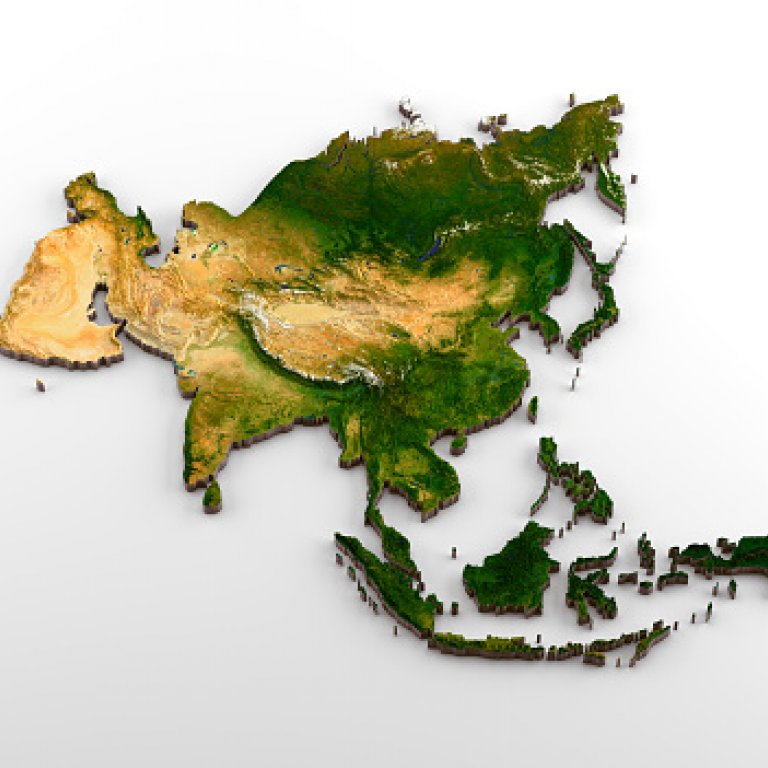 a magnifying glass focused on Asia on a map