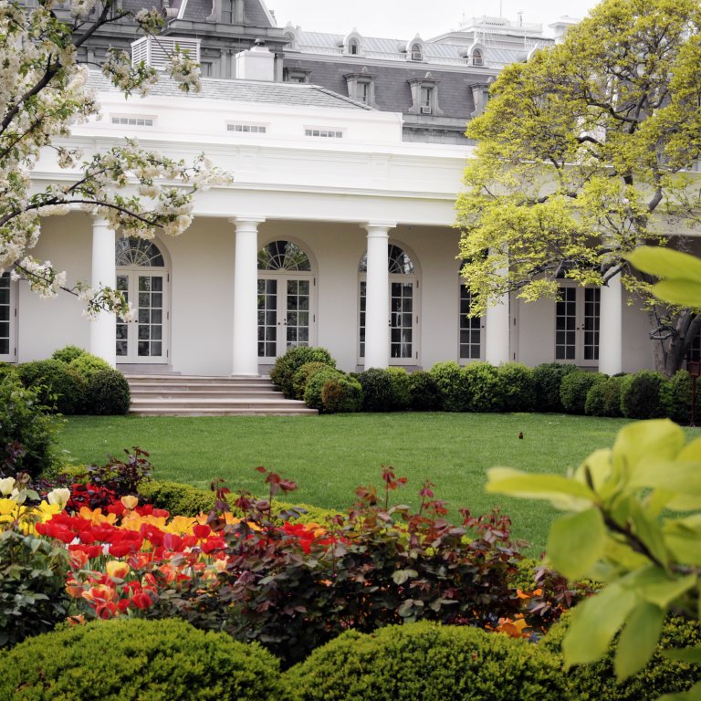 The  West Wing of the White House, partially obscured by trees