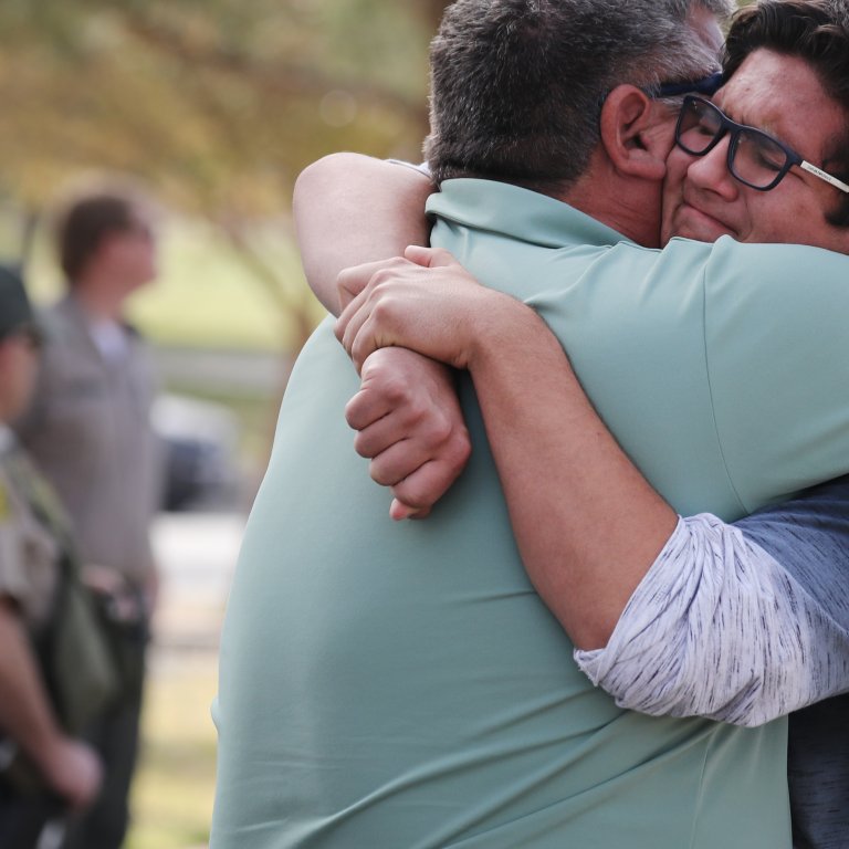 A boy hugs his father after a school shooting in Santa Clarita, CA.