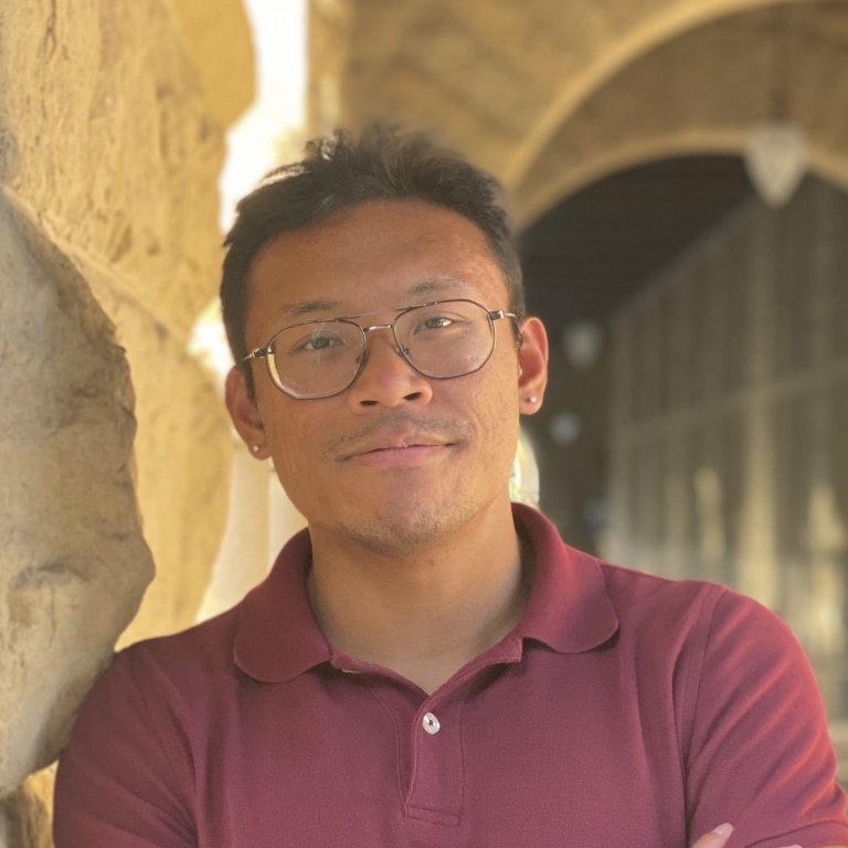 A headshot of Joseph Pagadora. Joseph is standing outside on the Stanford campus leaning against a pillar.