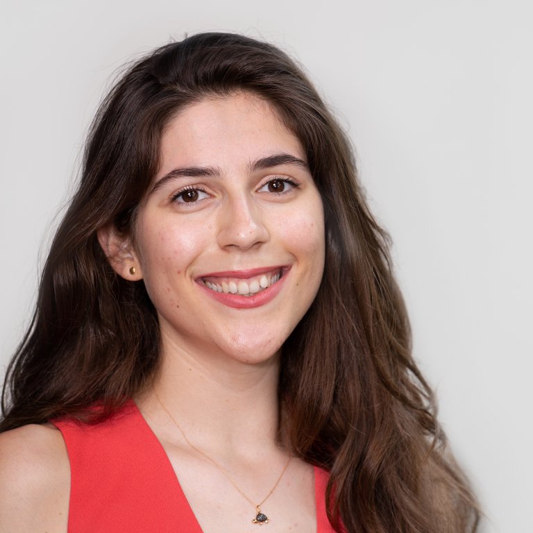 A headshot of Ilari Papa. Ilari is wearing an orange top.
