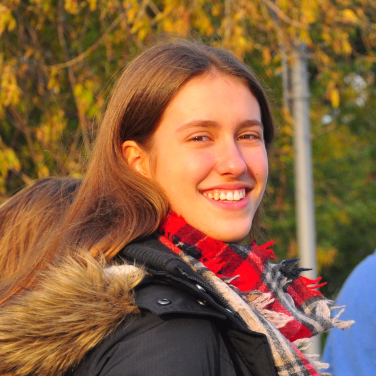 Headshot of Julia Betts Lotufo. Julia is looking over her right shoulder towards the camera and smiling