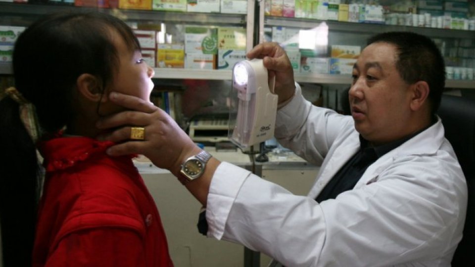 A doctor checks a young girl in a countryside clinic in China