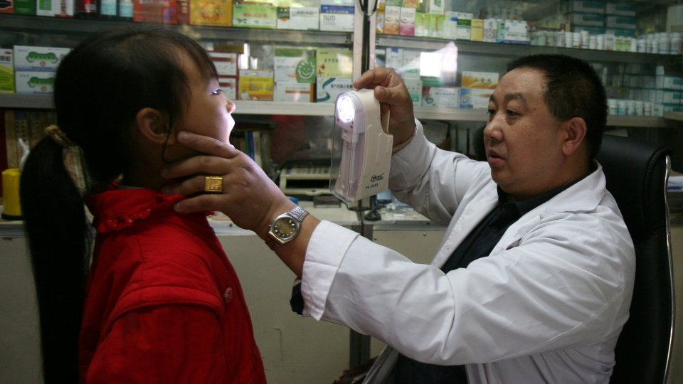 A doctor checks a young girl in a countryside clinic at Shihao Township on October 13, 2007 in Qijiang County of Chongqing Municipality, China.