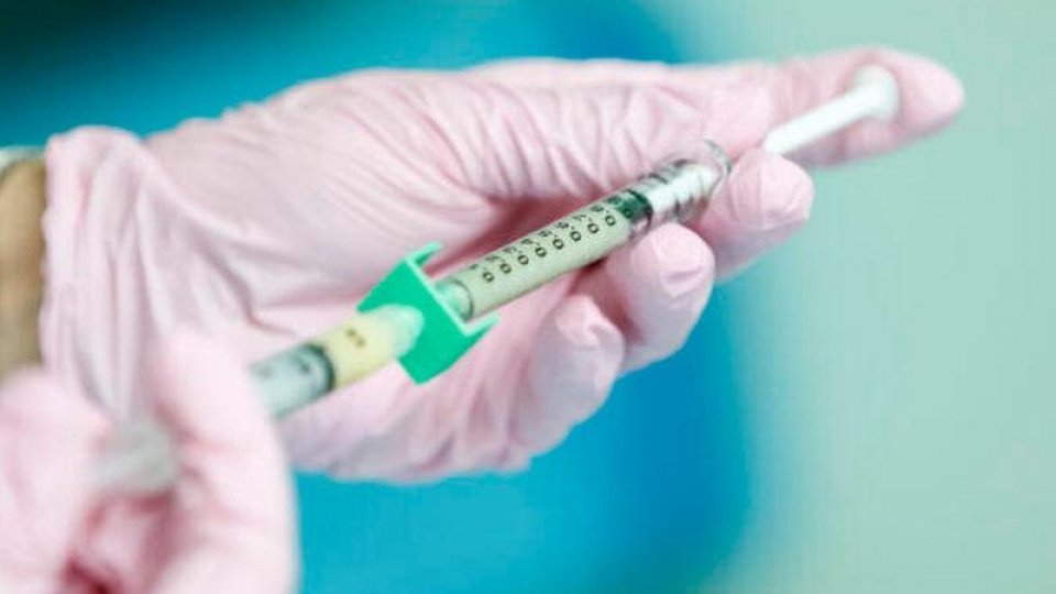 Hands holding a syringe to distribute a vaccine