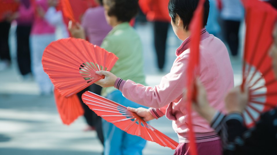 women dancing with red fans