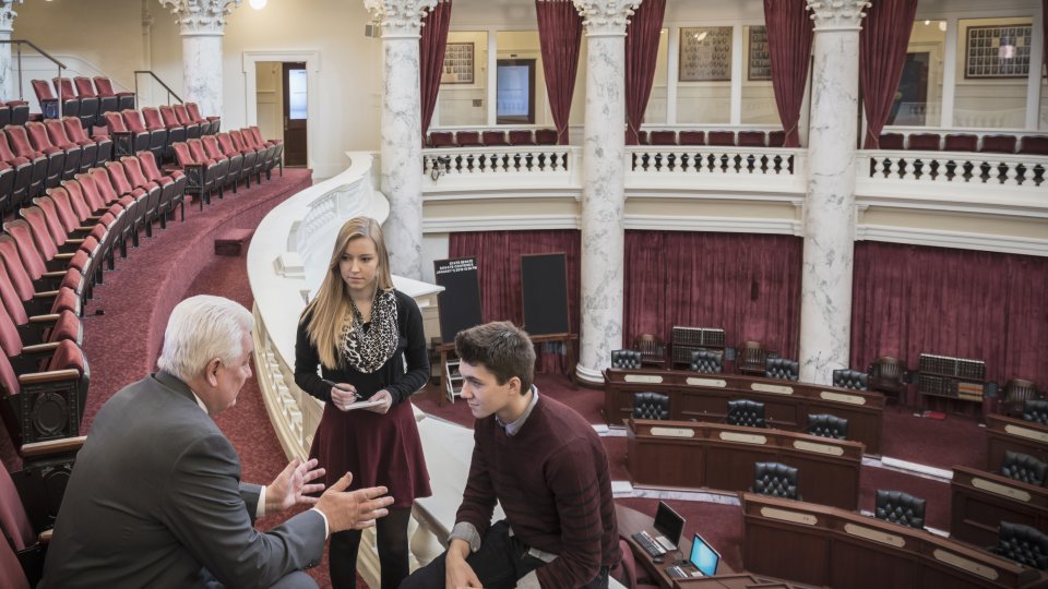 Caucasian teenagers talking to politician in capitol building Caucasian teenagers talking to politician in capitol buildin