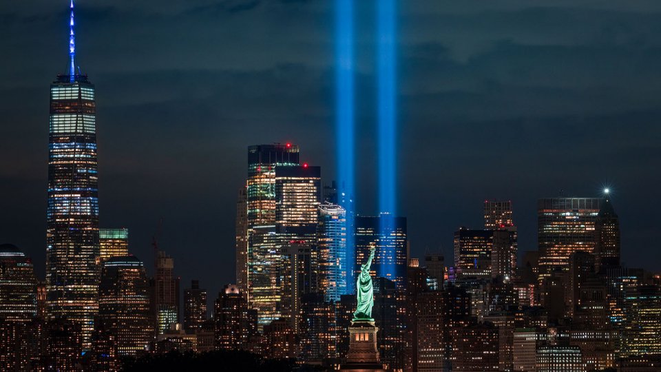 New York City skyline with The Tribute in Light 9/11 memorial and the Statue of Liberty.