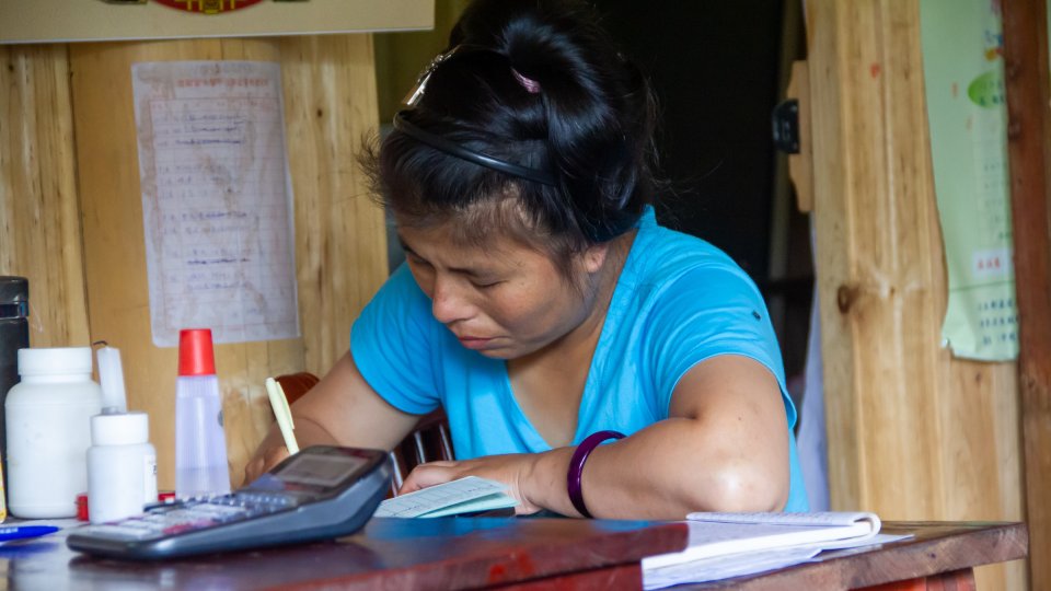 A woman at a desk in a village medical clinic in China.