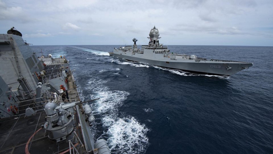 Two destroyer navy ships sail alongside each other