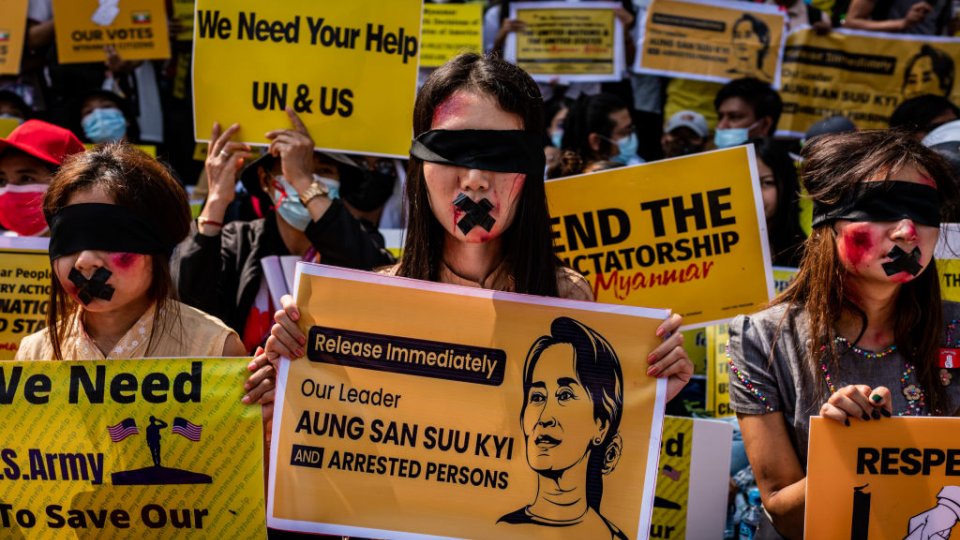 Protesters against the military coup in Myanmar hold banners.
