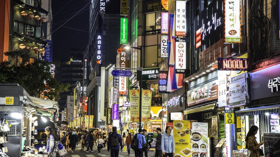 Crowds pass under the Myeongdong neon lights, Seoul, South Korea
