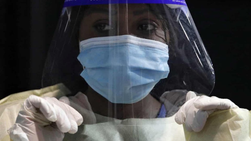 A female healthcare worker wears protective gear against the COVID-19 virus.