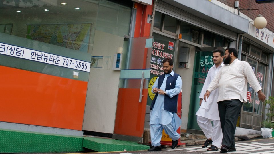 Three men wearing Islamic clothing walk down a street in the Itaewon neighborhood in Seoul, South Korea. Three men wearing Islamic clothing walk down a street in the Itaewon neighborhood in Seoul, South Korea.