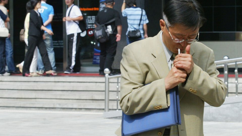 A man smokes in the street in Seoul, South Korea.