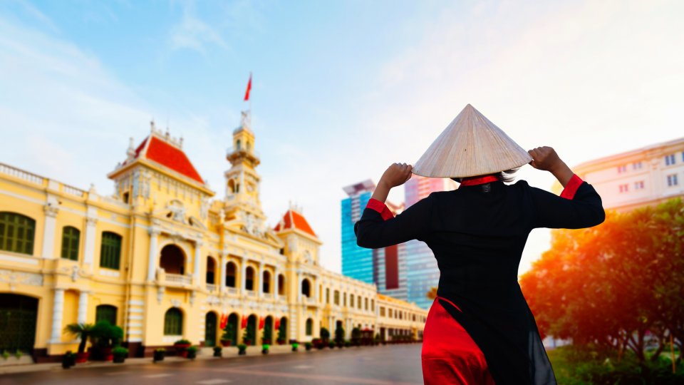 A woman wearing Ao Dai culture traditional at Ho chi minh city hall in Vietnam. Photo credit: Natnan Srisuwan via iStock/ Getty Images Plus. A woman wearing Ao Dai culture traditional at Ho chi minh city hall in Vietnam.