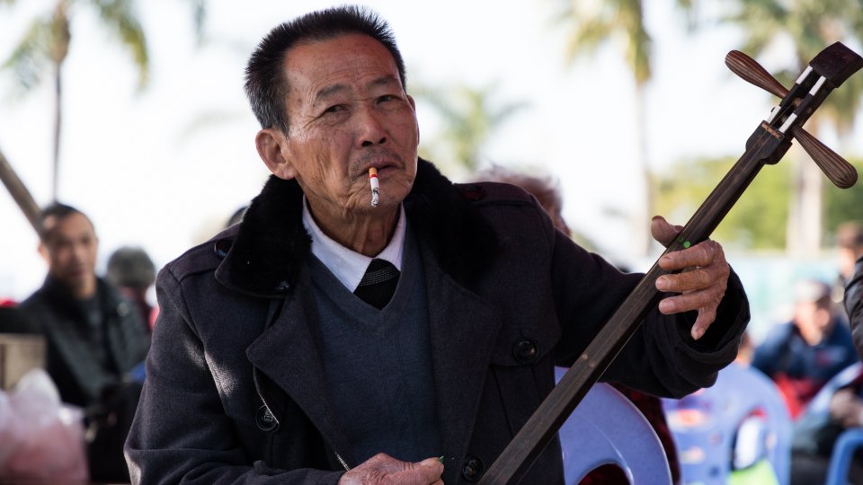Man smokes while playing an erxian