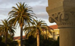 Architectural detail on Stanford colonnade with palm trees in the background 