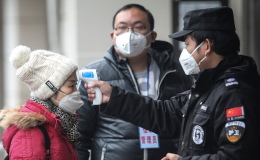 Security personnel check the temperature of passengers in the Wharf at the Yangtze River on January 22, 2020 in Wuhan, Hubei province, China.