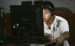 A man surfs the web in a netcafe in Youyang County of Chongqing Municipality, China