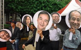 People hold pictures of Taiwanese presidential candidates
