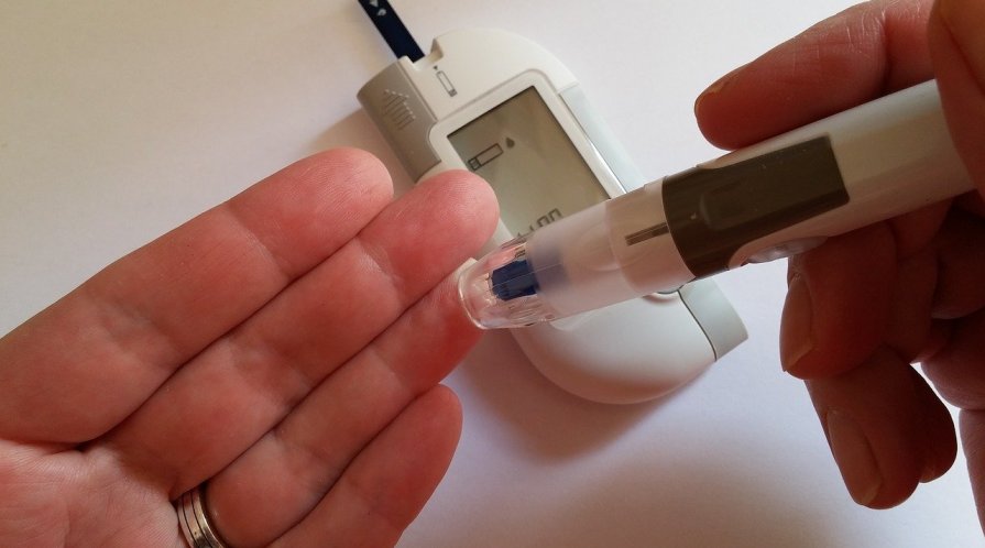 Closeup on hands holding a glucometer