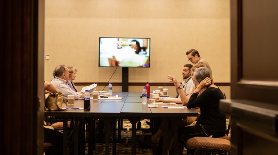 Group of people deliberating around a table