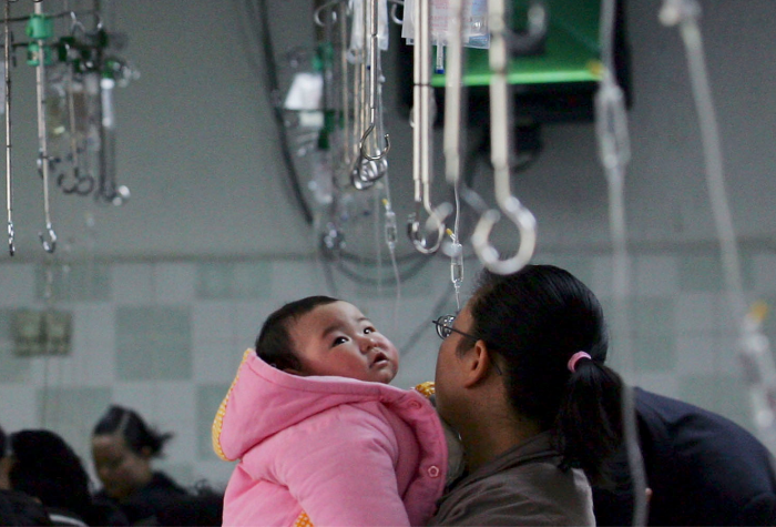 A parent holds a child waiting to be given an infusion at an area hospital in China.
