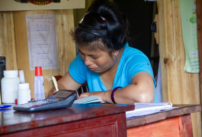 A woman at a desk in a village medical clinic in China.
