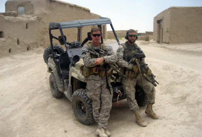 Two soldiers in front of car