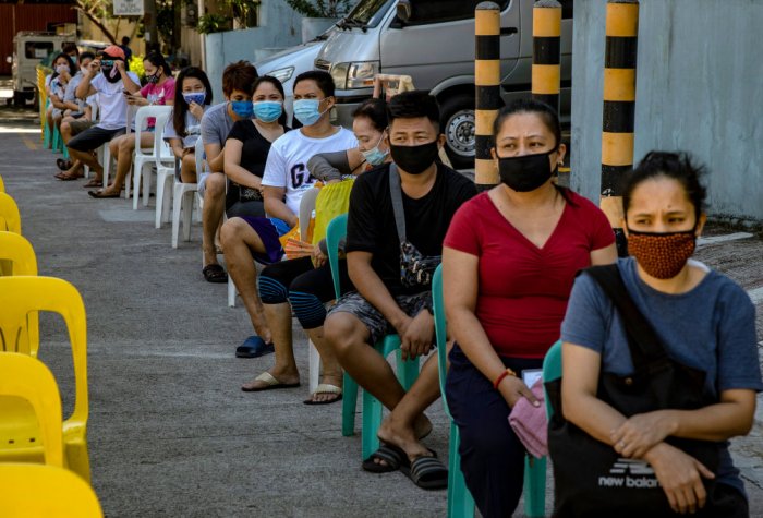 People queue while wearing face masks