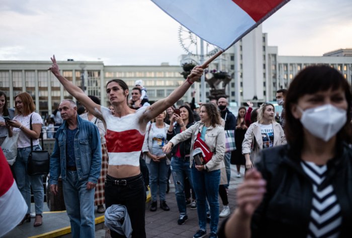 man waiving flag at protest in Belarus