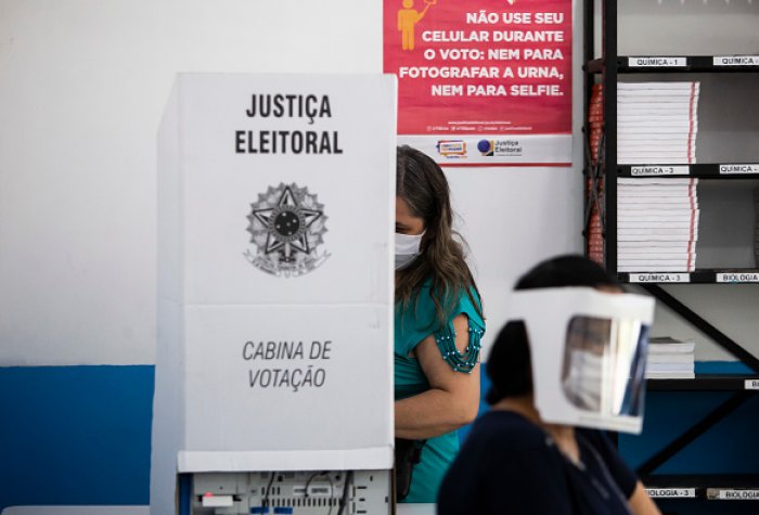Image of voter wearing a face mask and voting in a booth Image of voter wearing a face mask and voting in a booth