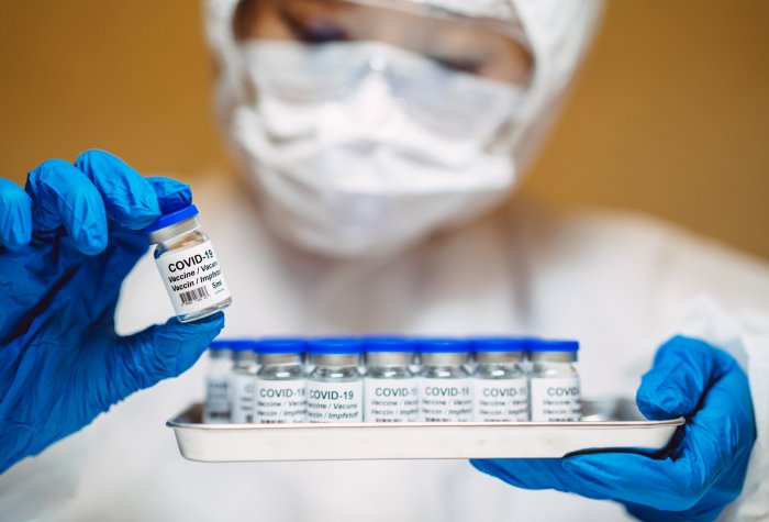A health-care worker holds up a COVID-19 vaccine