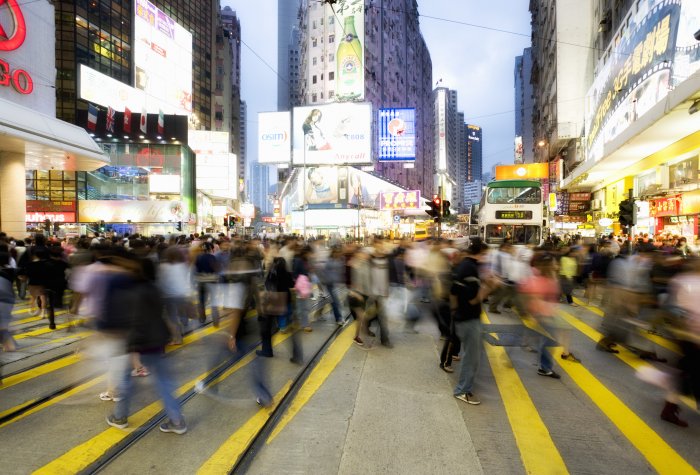 A busy crosswalk in a city with many people crossing the street in China.