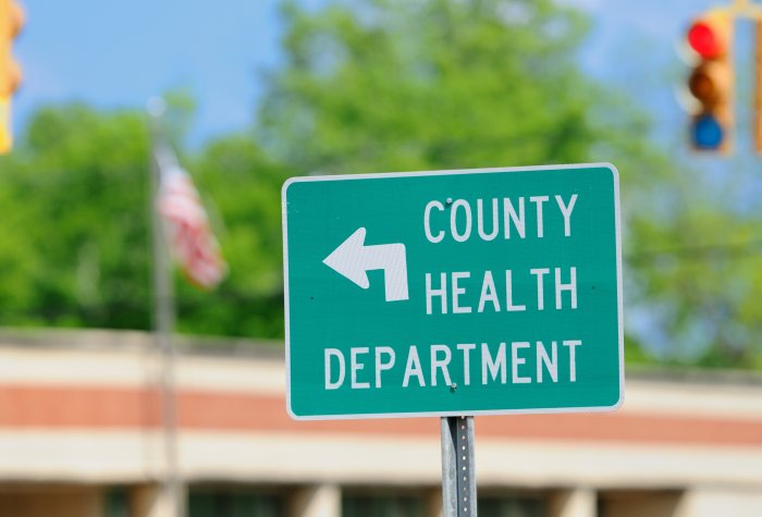 A traffic sign pointing to the county health department.