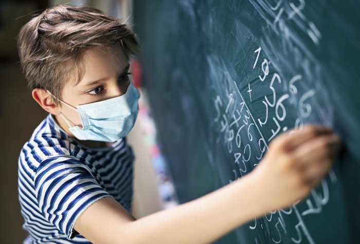 Boy in mask at chalkboard
