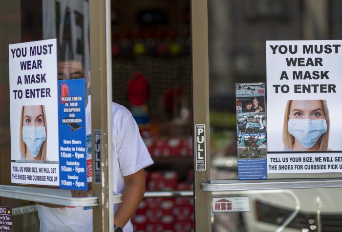 A man exits a Los Angeles County store where masks are required.