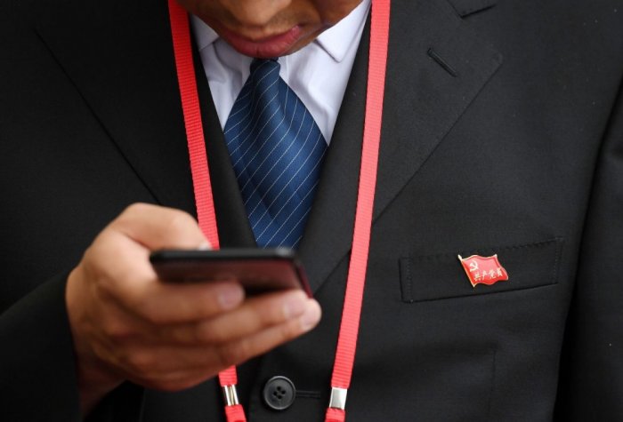 Person in suit looking at a smartphone