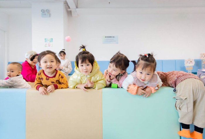 Toddlers pose for a picture at a brightly colored parenting center in Sichuan, China.