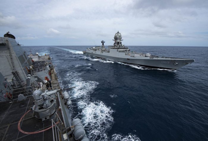 Two destroyer navy ships sail alongside each other